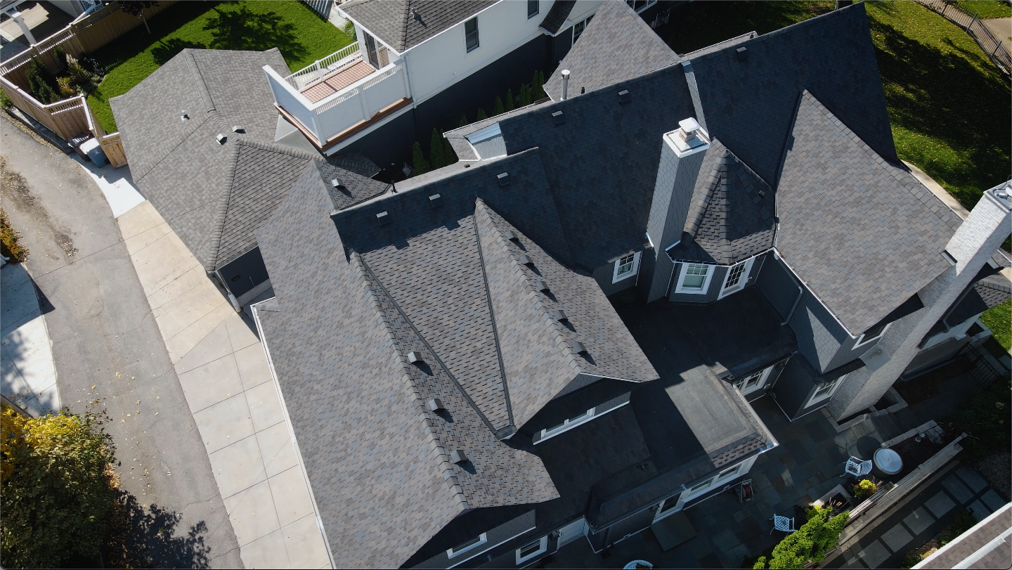Expertly Installed Residential Roof with Intricate Architectural Design Aerial view of a residential property featuring a professionally installed asphalt shingle roof with complex gables and dormers.